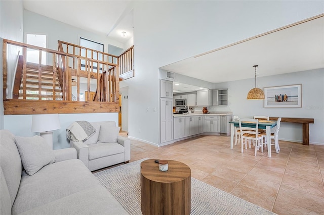 living room featuring light tile patterned flooring and a towering ceiling