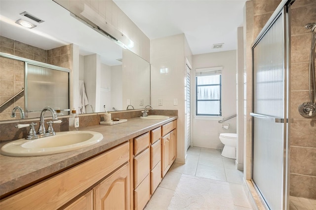 bathroom featuring walk in shower, vanity, toilet, and tile patterned flooring