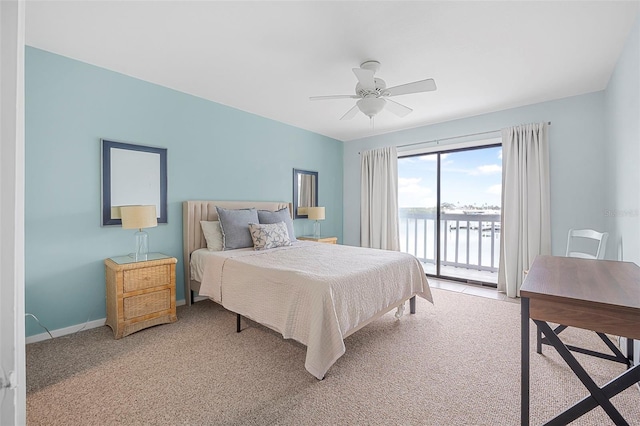 bedroom featuring access to exterior, carpet floors, ceiling fan, and a water view