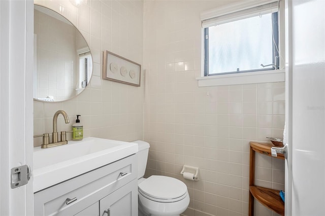 bathroom featuring tile walls, vanity, and toilet