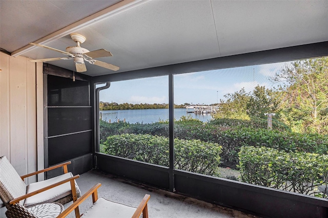 sunroom / solarium with a water view and ceiling fan