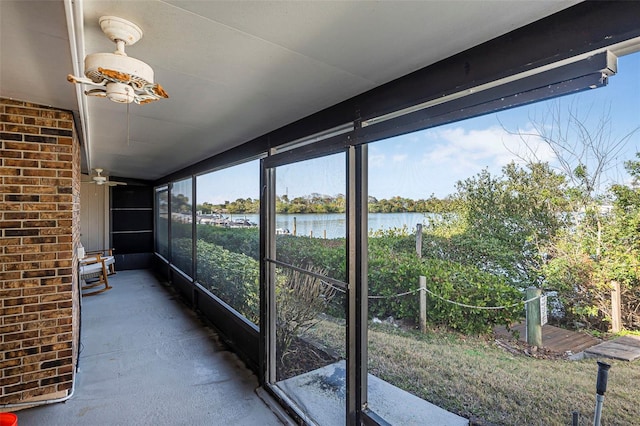 unfurnished sunroom with a water view and ceiling fan