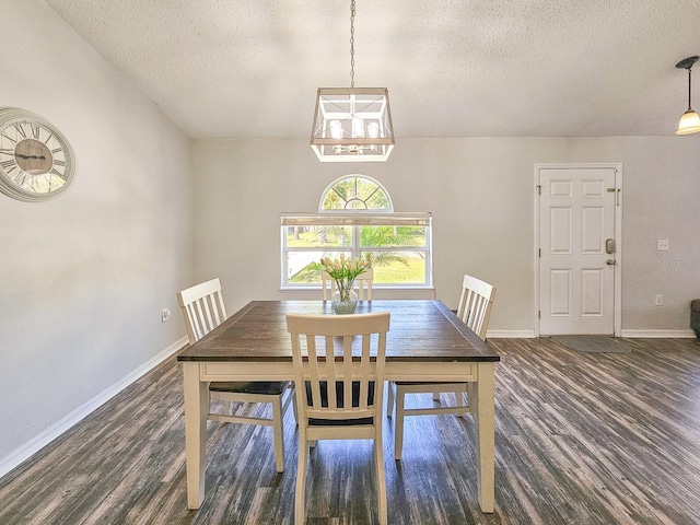 dining space featuring dark wood-type flooring and a textured ceiling