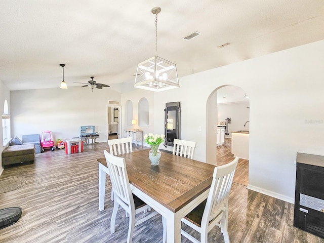 dining space featuring ceiling fan with notable chandelier and wood-type flooring