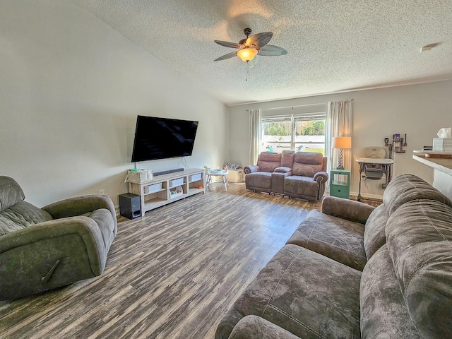 living room with vaulted ceiling, dark wood-type flooring, a textured ceiling, and ceiling fan