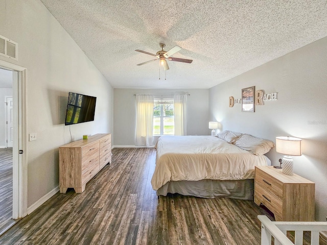 bedroom with ceiling fan, lofted ceiling, dark wood-type flooring, and a textured ceiling