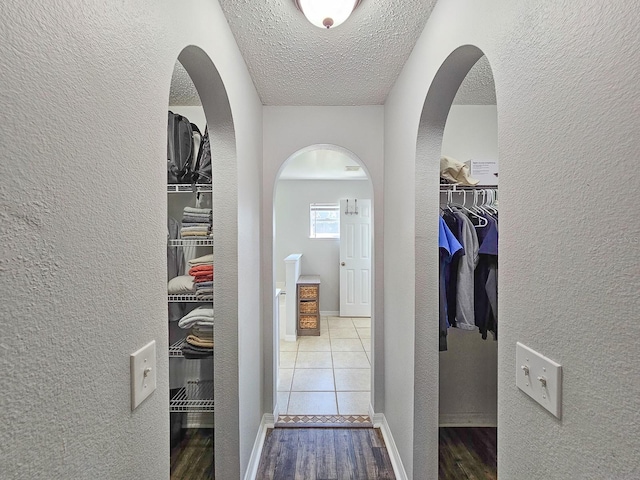 corridor with wood-type flooring and a textured ceiling