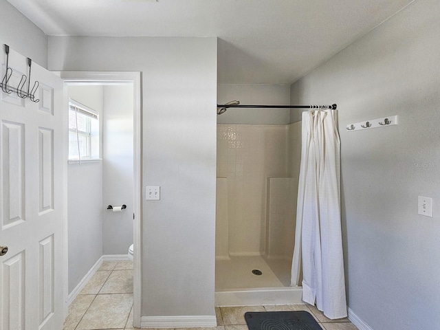 bathroom with toilet, tile patterned floors, and walk in shower