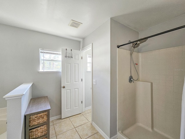 bathroom with tile patterned flooring and walk in shower