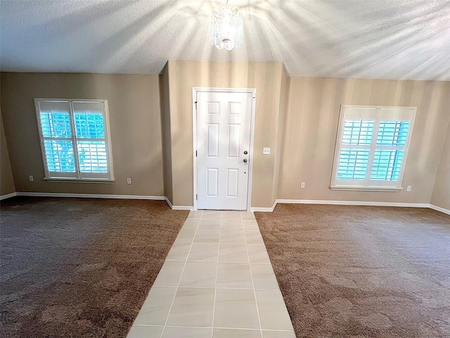 carpeted entryway featuring a textured ceiling