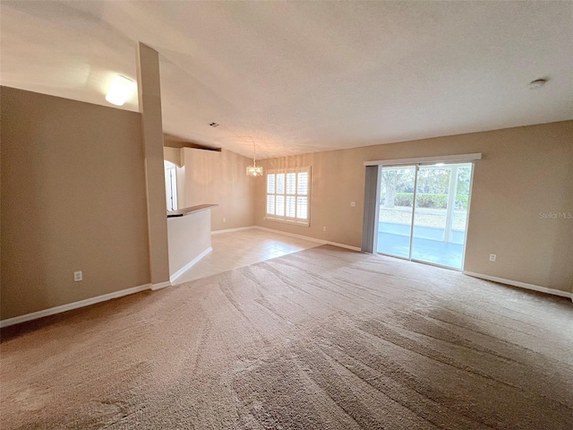 unfurnished living room featuring light colored carpet and a chandelier