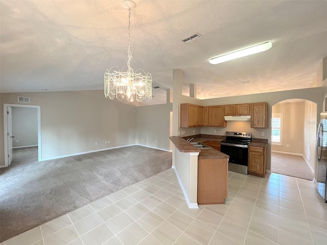 kitchen featuring hanging light fixtures, stainless steel appliances, a textured ceiling, light carpet, and kitchen peninsula