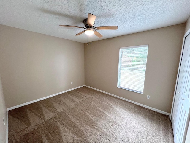 unfurnished room with ceiling fan, carpet floors, and a textured ceiling