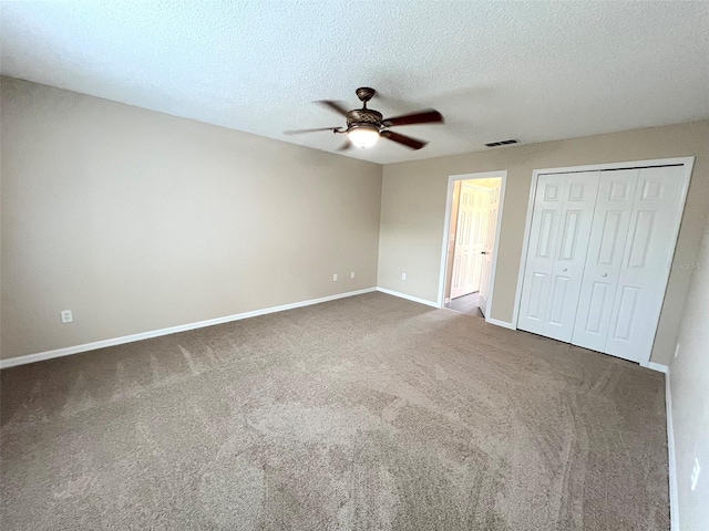 unfurnished bedroom with ceiling fan, carpet floors, a textured ceiling, and a closet