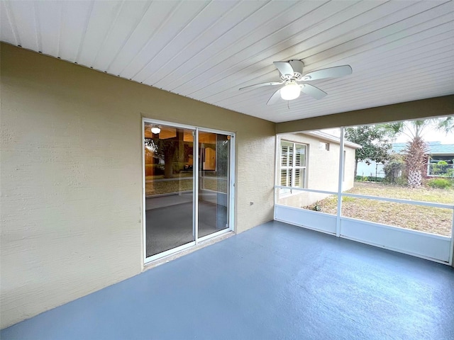 unfurnished sunroom with ceiling fan