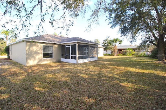 rear view of property featuring a yard and a sunroom