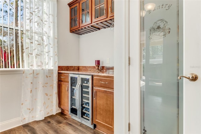 bar with wine cooler and dark wood-type flooring