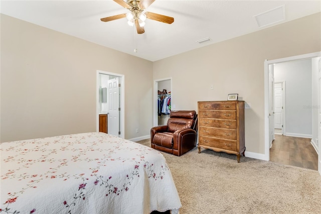 carpeted bedroom with ceiling fan, ensuite bathroom, a spacious closet, and a closet