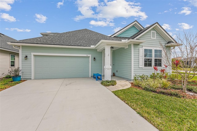 single story home featuring a shingled roof, a front yard, driveway, and an attached garage