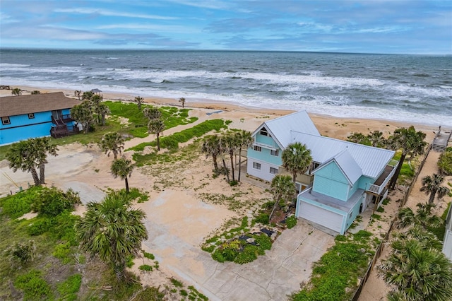 birds eye view of property featuring a water view and a beach view