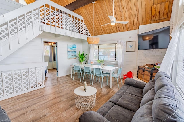 living area with beamed ceiling, plenty of natural light, wood finished floors, and wood ceiling