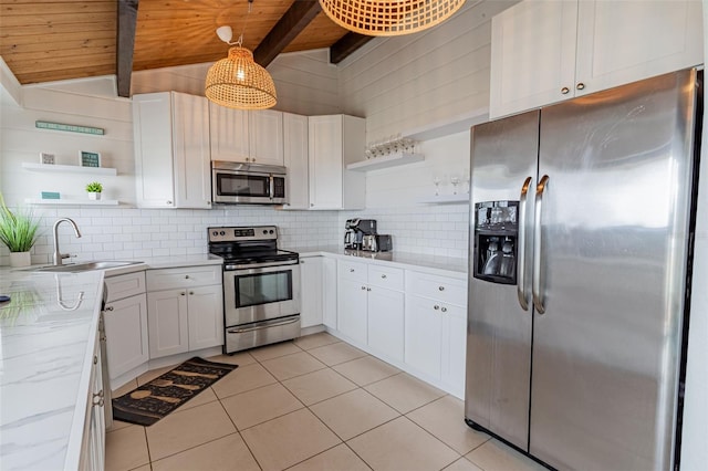 kitchen with tasteful backsplash, white cabinets, appliances with stainless steel finishes, open shelves, and a sink