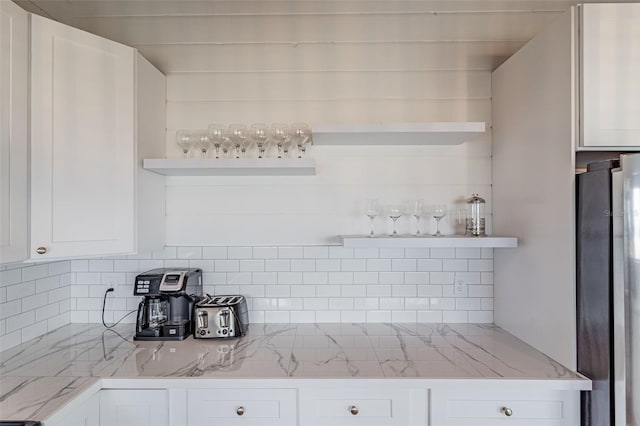 kitchen featuring open shelves, white cabinetry, and decorative backsplash