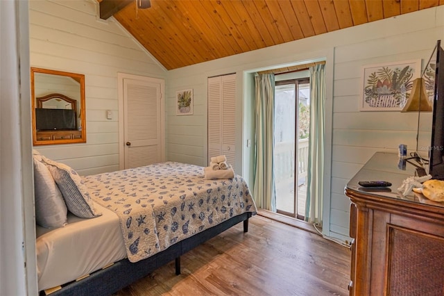 bedroom featuring lofted ceiling with beams, wooden ceiling, wood finished floors, access to exterior, and wood walls