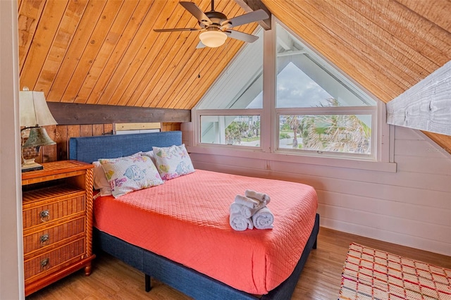 bedroom with vaulted ceiling, wood walls, wood finished floors, and wood ceiling