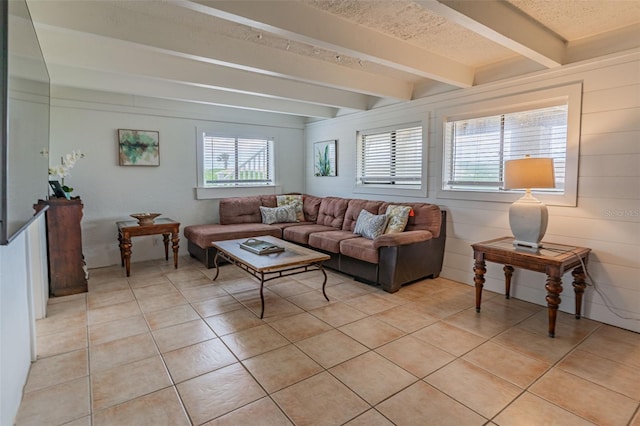 living area featuring light tile patterned floors, a textured ceiling, and beam ceiling