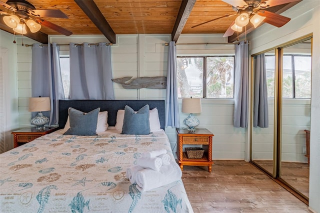 bedroom with wooden ceiling, wood finished floors, beam ceiling, and a ceiling fan