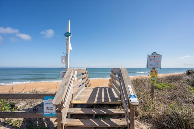 view of property's community with a water view and a beach view