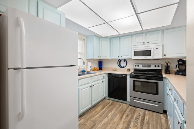 kitchen with white appliances, light hardwood / wood-style floors, and sink