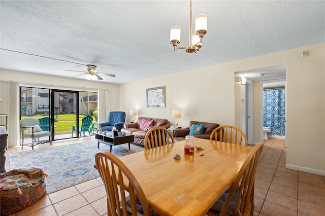 dining space featuring ceiling fan with notable chandelier, a textured ceiling, and light tile patterned floors