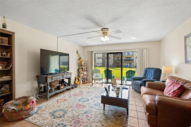 living room featuring light tile patterned flooring, ceiling fan, and a textured ceiling