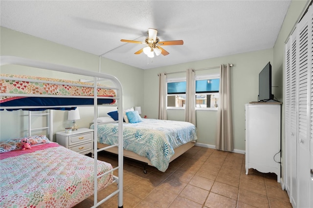 bedroom featuring ceiling fan, a textured ceiling, and light tile patterned floors