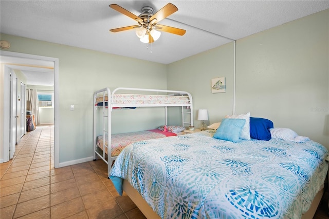 bedroom featuring ceiling fan, tile patterned floors, and a textured ceiling