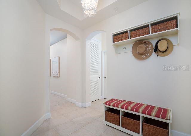 mudroom featuring tile patterned flooring and an inviting chandelier