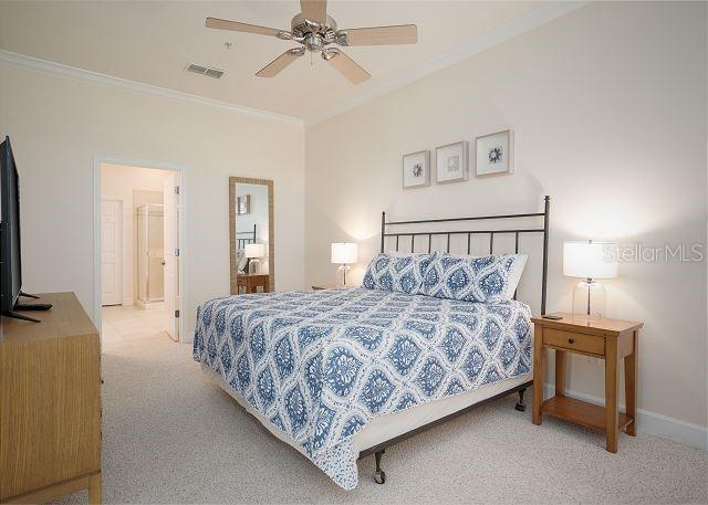 carpeted bedroom with crown molding and ceiling fan