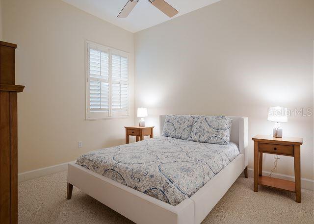 bedroom featuring light carpet and ceiling fan