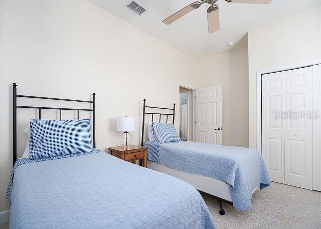 carpeted bedroom with ceiling fan and a closet