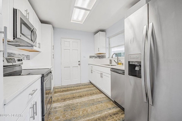 kitchen with white cabinetry, sink, light hardwood / wood-style flooring, and appliances with stainless steel finishes