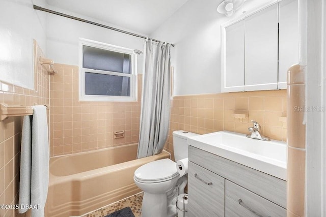 full bathroom featuring toilet, tile walls, vanity, and shower / bath combo with shower curtain