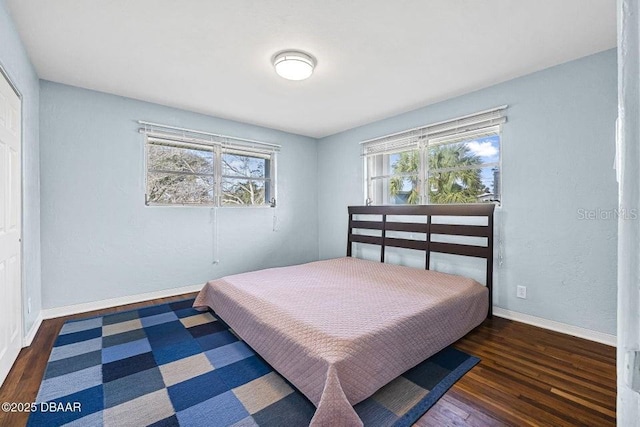 bedroom featuring multiple windows and dark hardwood / wood-style floors