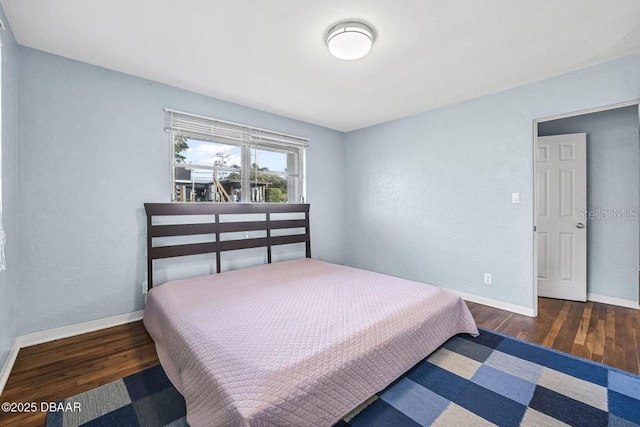 bedroom with dark hardwood / wood-style floors