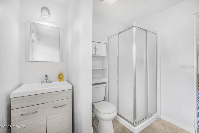 bathroom with an enclosed shower, vanity, and toilet