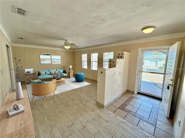155 Avalon Ave, Flagler Beach, FL 32136 - living room featuring crown molding, ceiling fan, brick wall, and light hardwood / wood-style floors
