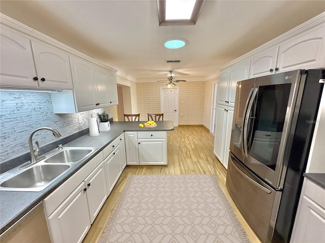 155 Avalon Ave, Flagler Beach, FL 32136 - kitchen featuring stainless steel refrigerator, sink, backsplash, white cabinets, and kitchen peninsula
