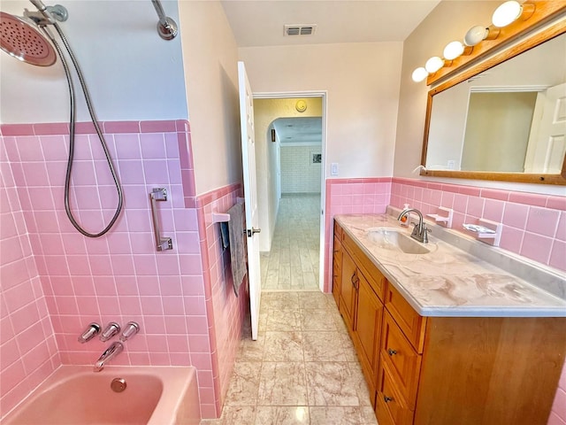 155 Avalon Ave, Flagler Beach, FL 32136 - bathroom with tiled shower / bath combo, vanity, and tile walls