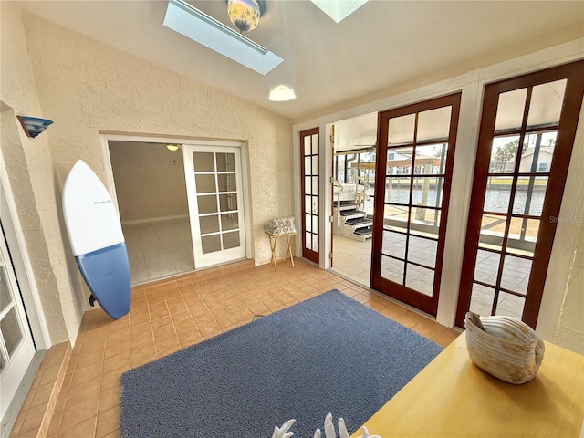 155 Avalon Ave, Flagler Beach, FL 32136 - doorway featuring tile patterned floors, french doors, and vaulted ceiling with skylight